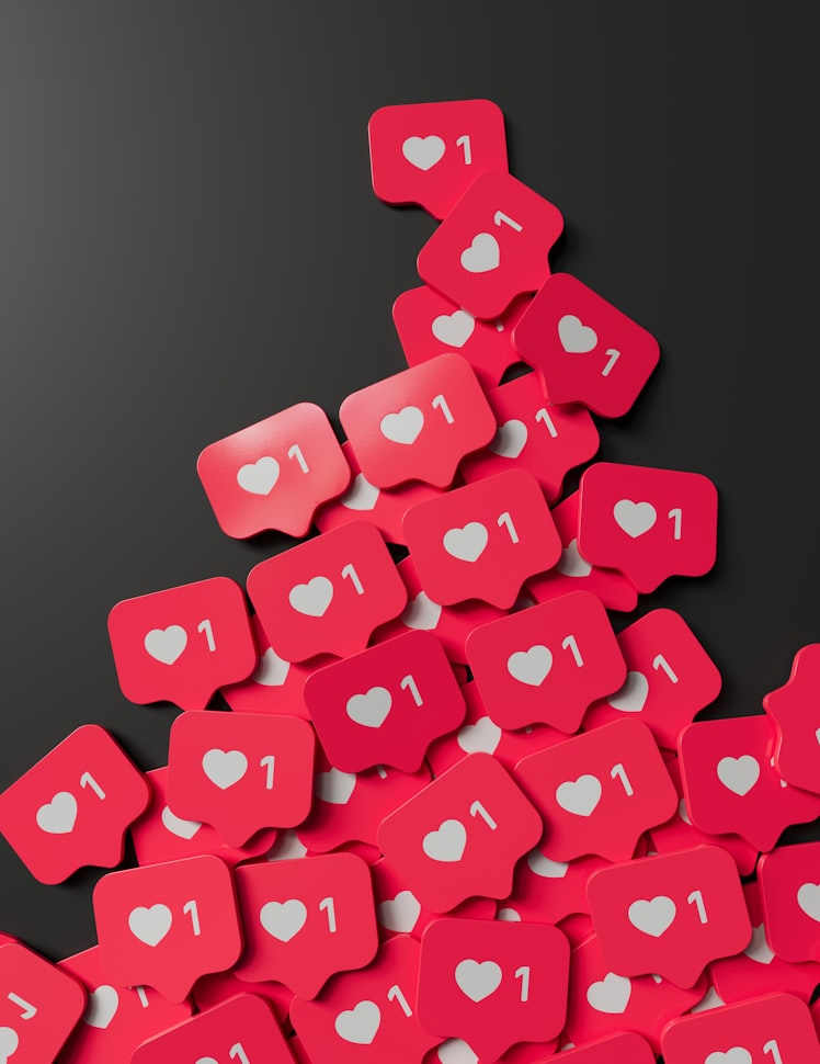 A bunch of white hearts on small pink regtangular tags against a dark background.